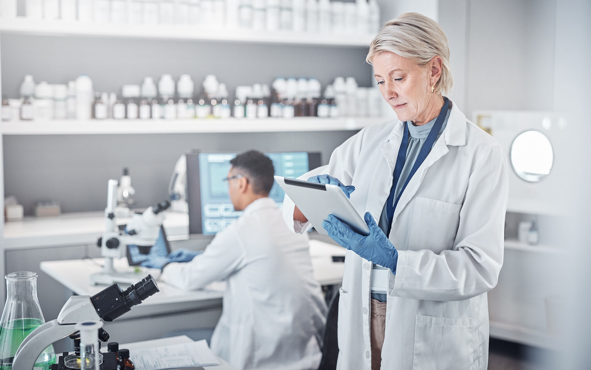 Senior scientist woman, tablet and laboratory for analysis, research or focus in pharmaceutical study. Science team, lab or planning for future virus, bacteria or vision for pharma solution in Sweden.